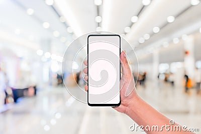 Mockup image of hand holding mobile phone with blank white screen with blur office corridor hall way background bokeh light,White Stock Photo