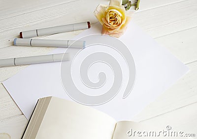 Mockup for A4 paper with single rose, book and drawing material Stock Photo