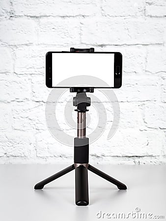 Mockup with smartphone on a tripod with empty screen Stock Photo