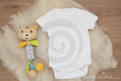 Mockup of white baby bodysuit on wood background. Blank baby clothes template mock up. Flat lay styled stock photo Stock Photo