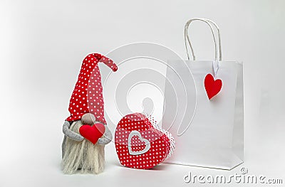 Mockup of a white package with a gnome and a gift box on a light background. Idea valentine's day Stock Photo