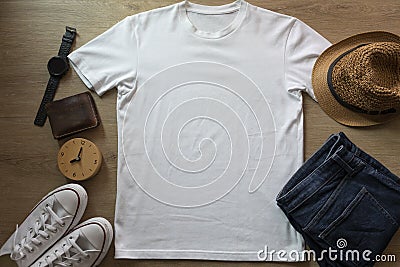 Mockup of a white t-shirt blank shirt template with accessories on the wooden table background, lifestyle and travel concept Stock Photo