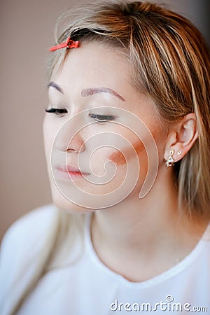 Model while applying makeup, contouring cheekbones. Stock Photo