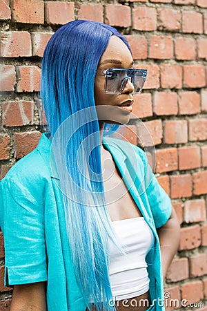 Model with blue hair wearing a white top and a turquoise jacket Editorial Stock Photo