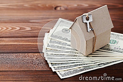 Model cardboard home, key and dollar money. House building, insurance, housewarming, loan, real estate, cost of housing, buying Stock Photo