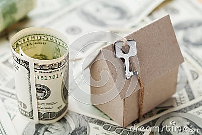 Model cardboard home, key and dollar money. House building, insurance, housewarming, loan, real estate, cost of housing, buying Stock Photo