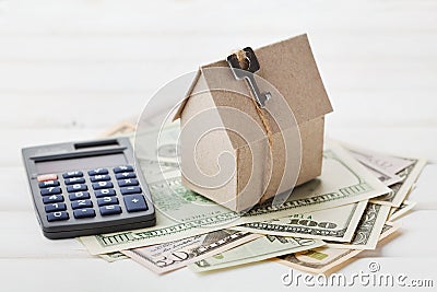 Model of cardboard house with key, calculator and cash dollars. House building, loan, real estate. Cost of public utilities. Stock Photo