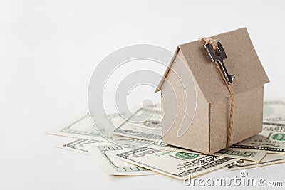 Model of cardboard house with key and dollar bills. House building, loan, real estate, cost of housing or buying a new home concep Stock Photo