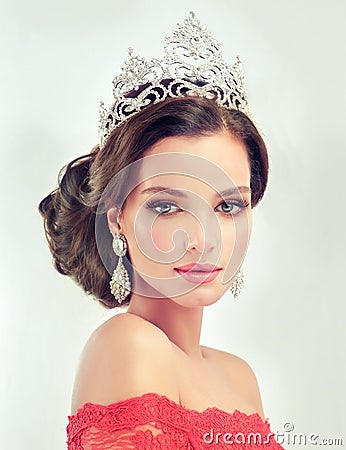 Model in a delicate make up, dressed in a red gown and crown. Stock Photo