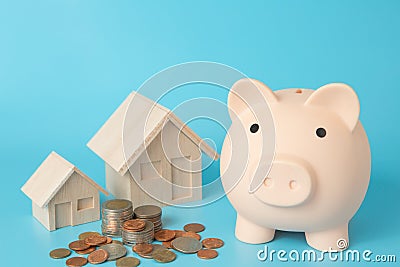 Model house, coins stack, Pig piggy bank on blue background for money saving concept Stock Photo