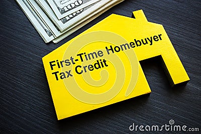 Model of a house with an inscription First time homebuyer tax credit and money. Stock Photo