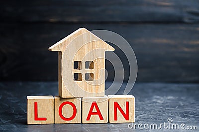 Model of the house and the inscription `Loan`. Buying a home in debt. Family investment in real estate and risk management concept Stock Photo