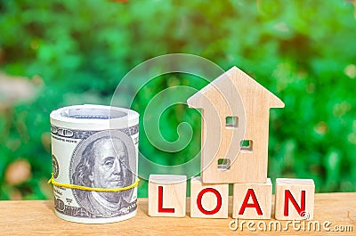 Model of the house, money and the inscription `Loan`. Buying a home in debt. Family investment in real estate and risk management Stock Photo