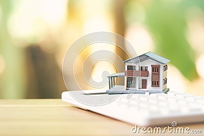 A model house model is placed on a calculator. as background property real estate concept with copy space Stock Photo