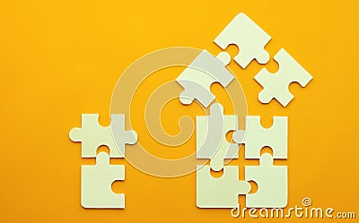 Model of a house on a uniform yellow background for the concept of real estate loans with space for text. Close-up Stock Photo