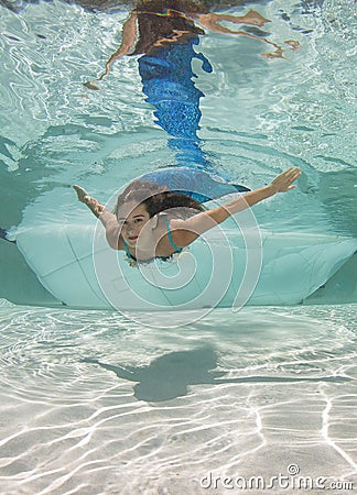 Model in a pool wearing a mermaid`s tail. Stock Photo
