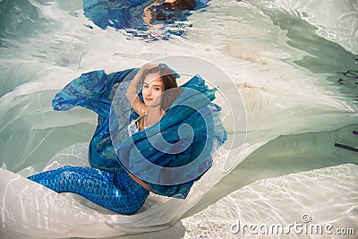 Model in a pool wearing a mermaid`s tail. Stock Photo