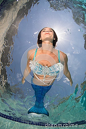 Model in a pool wearing a mermaid`s tail. Stock Photo