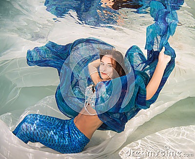 Model in a pool wearing a mermaid`s tail. Stock Photo