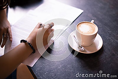 Model release document writing by woman tender hand in cafe table with cup of coffee office concept Stock Photo