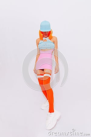 Model 90s party hip-hop, sport, fitness style posing in white studio. Trendy cap and stocking. Urban and fashion concept Stock Photo