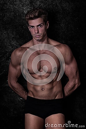 Model man in underwear, black grunge background Stock Photo