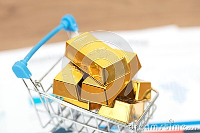 Model shopping cart filled with gold bars Stock Photo