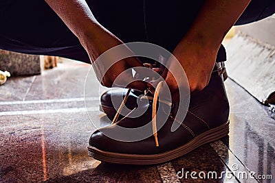 Model tiding laces of his brown color boots Stock Photo