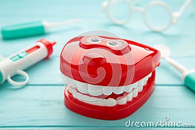 Model toys teeth with dentist instrument on blue background Stock Photo
