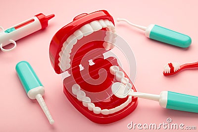Model toys teeth with dentist instrument on pink background Stock Photo