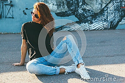 Model wearing plain tshirt and sunglasses posing over street wall Stock Photo