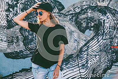 Model wearing plain tshirt and sunglasses posing over street wall Stock Photo