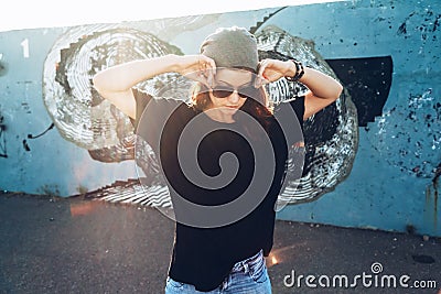 Model wearing plain tshirt and sunglasses posing over street wall Stock Photo