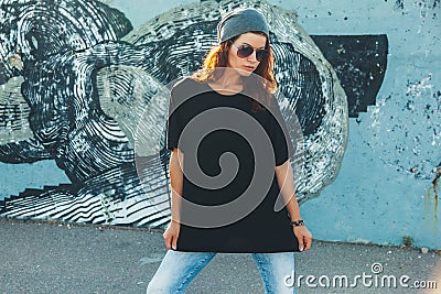 Model wearing plain tshirt and sunglasses posing over street wall Stock Photo