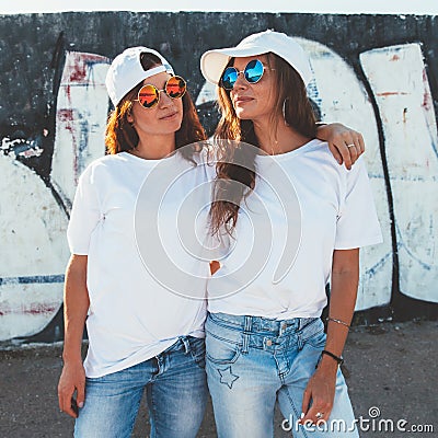 Models wearing plain tshirt and sunglasses posing over street wa Stock Photo