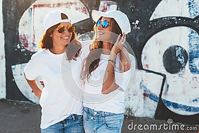 Models wearing plain tshirt and sunglasses posing over street wa Stock Photo