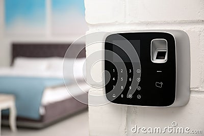 Modern alarm system with fingerprint scanner on brick wall in house Stock Photo