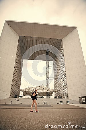 Modern architecture. Backpacker exploring city. Summer vacation. Woman stand in front of urban architecture. Must visit Stock Photo