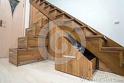 Modern architecture interior with luxury hallway with glossy wooden stairs in multi-storey house. Custom built pullout cabinets on Stock Photo