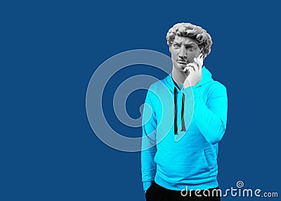 Modern art collage. Concept portrait of a man holding mobile smartphone using app texting sms message. Gypsum head of of David. Stock Photo