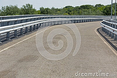 Modern asphalt road with metal fences and walkway closeup Stock Photo