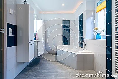 Modern Bathroom - Glossy white and blue tiles - bathtub, sink and floor heating Stock Photo