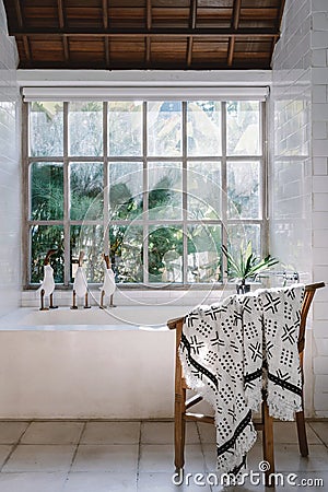 Modern bathroom interior, chair near built bathtub against large window Stock Photo