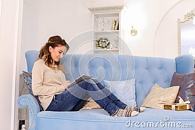 Modern beautiful woman sits on Internet and scrolls on tablet ne Stock Photo