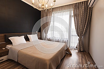 Modern bedroom interior design. Luxury bed room with brown color tone. Windows with long curtains and sheers Stock Photo