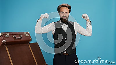 Modern bellboy flexing muscles in studio Stock Photo