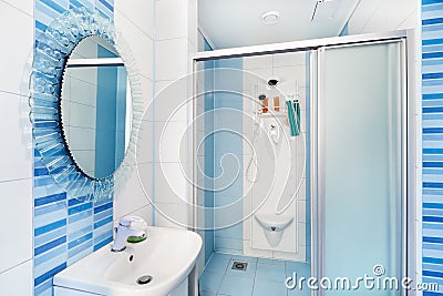 Modern blue bathroom interior with round mirror Stock Photo