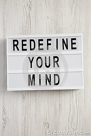 Modern board with text `Redefine your mind` over white wooden background, top view. Overhead, flat lay Stock Photo