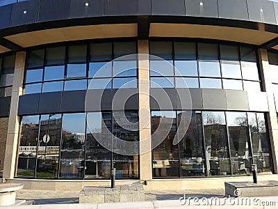 Modern building with city reflections on glass windows. Stock Photo