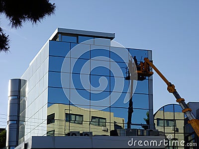 Modern Building Window Washing From Elevated Cherry Picker Lift Stock Photo